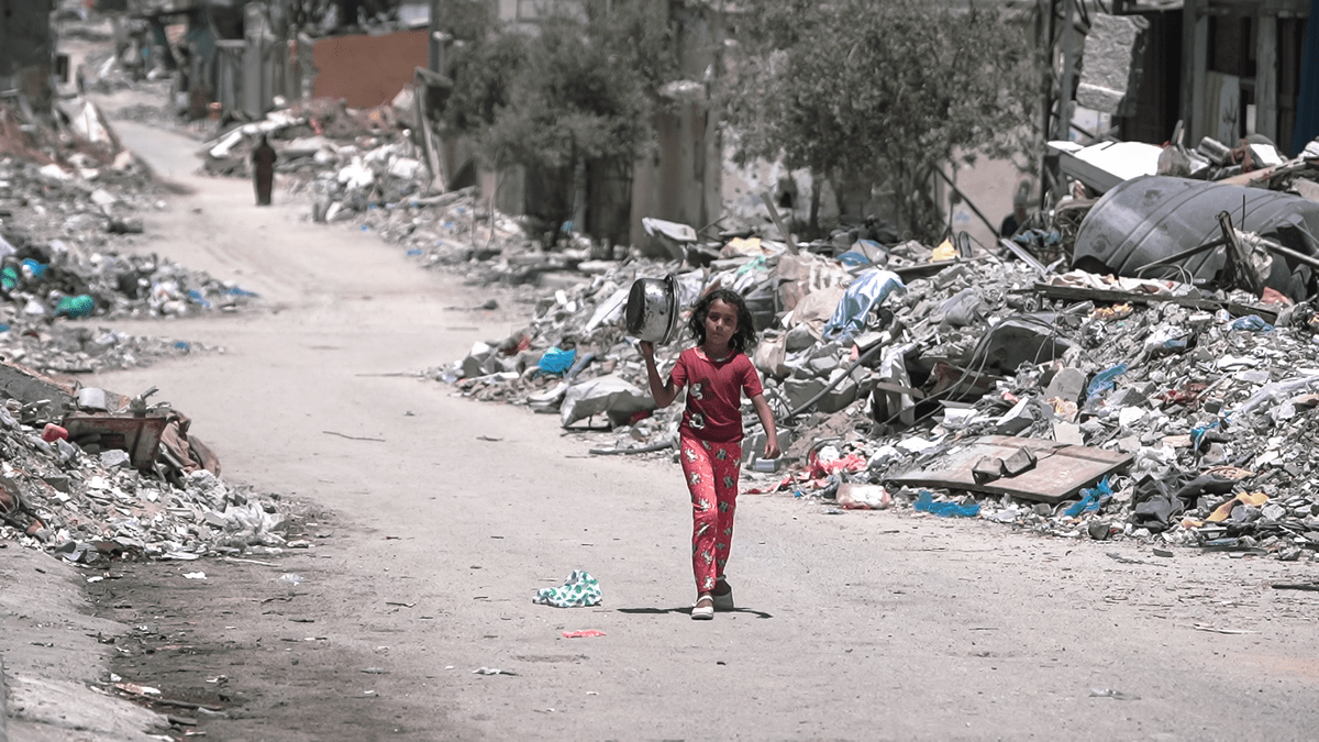 A_girl_walks_inside_Gaza_during_the_Gaza-Israel_war_to_get_food GAZA